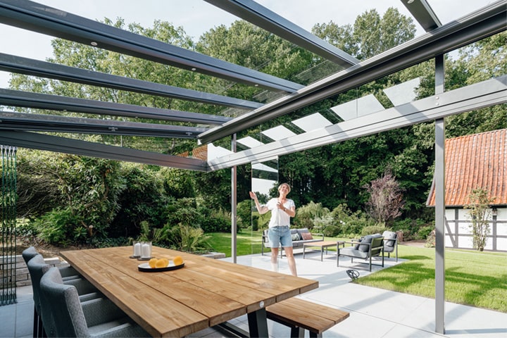 Die seitlichen Glaselemente der Terrassenüberdachung lassen sich einfach zur Seite schieben, flexibel öffnen und schließen – je nach Wetterlage.