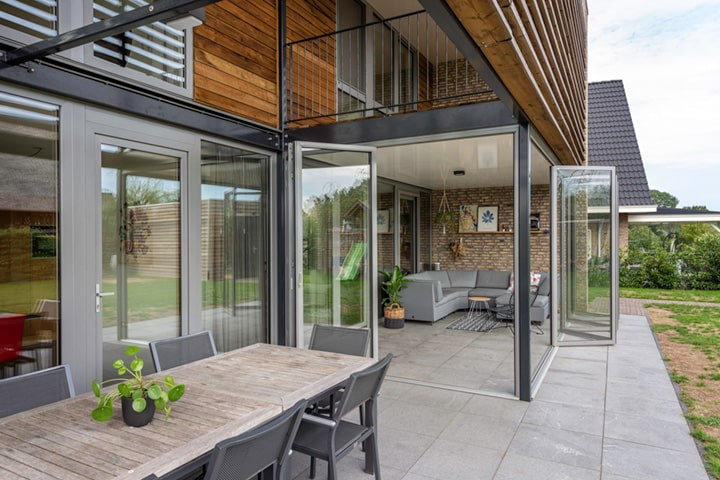 Sogar im Winter heizt sich der verglaste Terrassenbereich so angenehm auf, dass die Familie die innere Verglasung öffnet und die Wärme in den Wohnbereich strömen lässt.