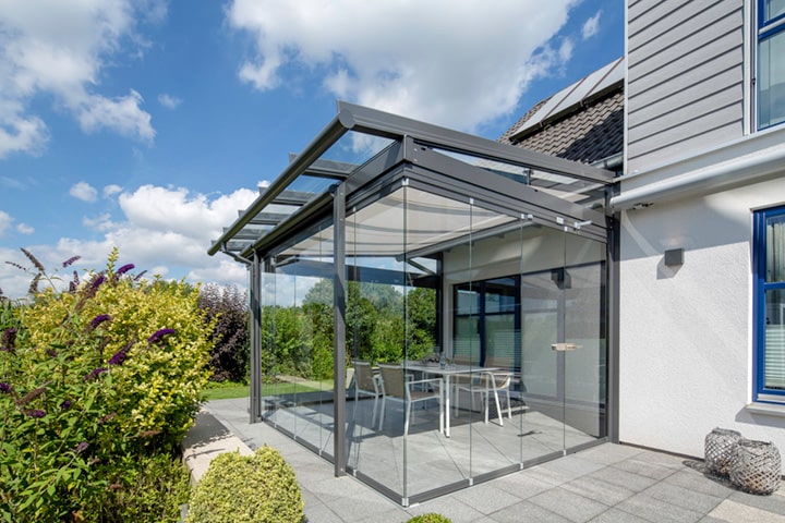 Mit seitlichen Glaselementen wird die Terrassenüberdachung zum Allwetterplatz. Die Verglasung lässt sich flexibel öffnen und schließen.
