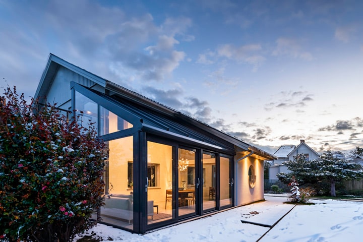 Die hochwärmegedämmten Wintergärten von Solarlux zeigen ihren Charme besonders im Winter. In gemütlicher Atmosphäre können Bauherr*innen den Schnee fallen sehen.