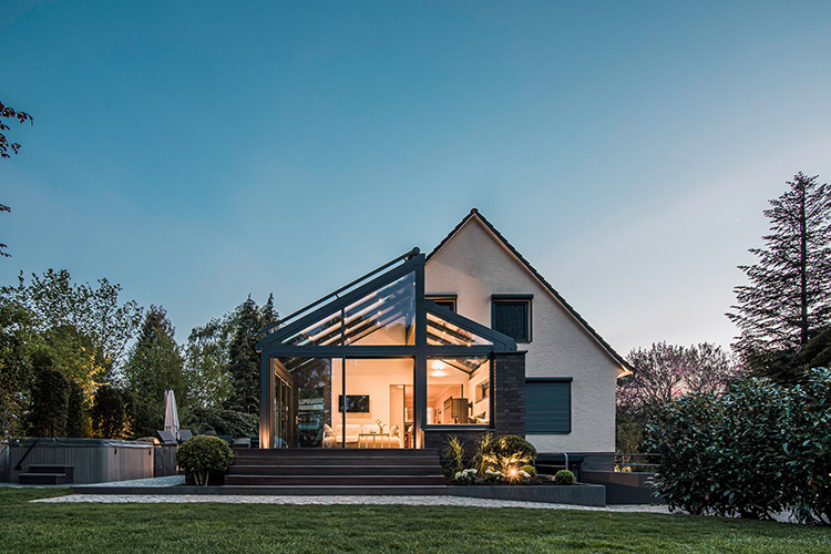 Großzügige Verglasungen holen das Herbstlicht ins Haus und schaffen einen hellen, behaglichen Lebensraum, der Wohnraum und Garten miteinander verbindet.