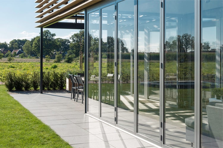 Ein Teil der Terrasse ist wie eine zweite Haut von einer Glas-Faltwand umschlossen.