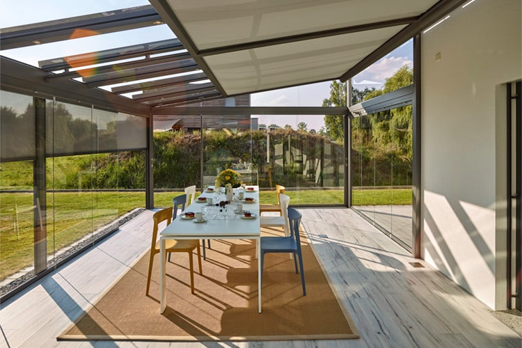 Ein Teil der Terrasse ist wie eine zweite Haut von einer Glas-Faltwand umschlossen.