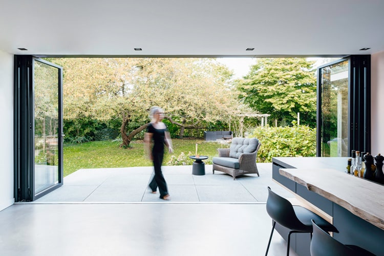 Die Glas-Faltwand von Solarlux lässt sich über die gesamte Breite öffnen und schafft eine nahtlose Verbindung zwischen innen und außen.